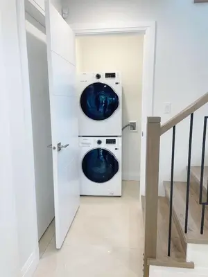 two washing machines in a white laundry room at Brand new, cozy first floor room for staying in Vancouver