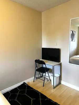a room with a desk with a chair and a television at The house Londonderry mall in Edmonton