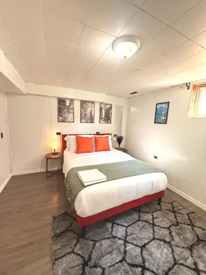 a bedroom with a large bed with orange pillows at The house Londonderry mall in Edmonton
