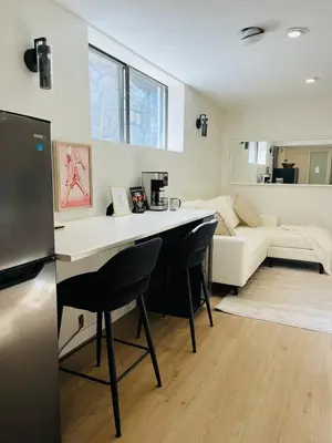 a kitchen and living room with a table and a couch at The Chimney Studio with Gigantic Outdoor Fireplace in Calgary