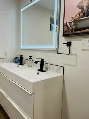 a bathroom with a white sink and a mirror at The Chimney Studio with Gigantic Outdoor Fireplace in Calgary