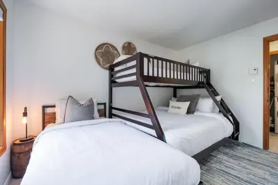 a bedroom with two bunk beds and a rug at Painted Cliff by Outpost Whistler in Whistler