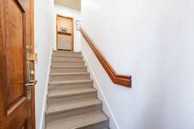 a staircase in a house with a wooden door at Painted Cliff by Outpost Whistler in Whistler