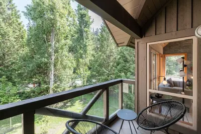 a room with a balcony with a view of trees at Painted Cliff by Outpost Whistler in Whistler