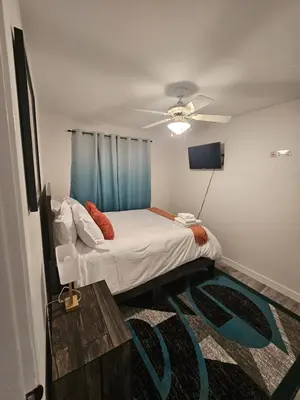 a bedroom with a bed with a ceiling fan at Aansel Suites QUEEN ROOM in Edmonton