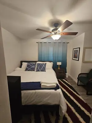 a bedroom with a bed with a ceiling fan at Aansel Suites QUEEN ROOM in Edmonton