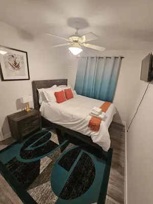 a bedroom with a bed and a ceiling fan at Aansel Suites QUEEN ROOM in Edmonton