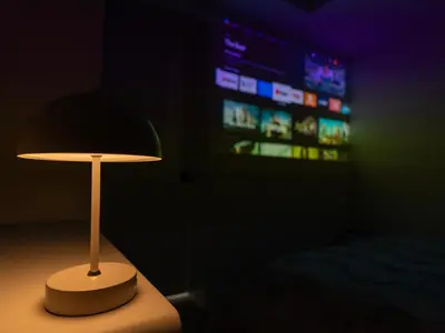 a lamp in a dark room with a tv at Quiet, cozy 2BR1BA private entry suite near Skytrain in Vancouver