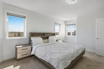 a white bedroom with a bed and two windows at Acreage, 5 bdrm, King Bed, AC, Wood Fireplace, Rural in Balzac