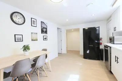 a kitchen with a table and a black refrigerator at Quiet Family Friendly, 4 min UofC and University District Shops, 9 min DT in Calgary