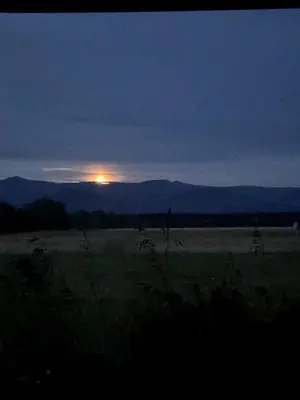 a sunset in a field with the sun in the distance at Cabin with Fields of Dreams in Whitehorse