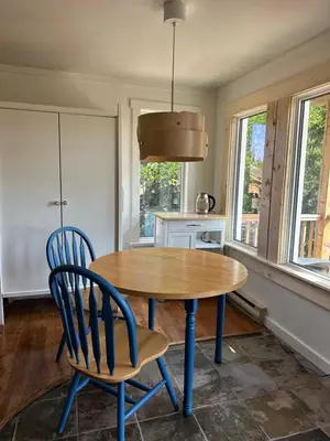 a kitchen with a wooden table and two chairs at Cabin with Fields of Dreams in Whitehorse