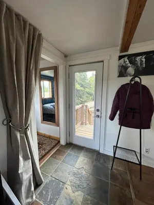a room with a door with a window and a chair at Cabin with Fields of Dreams in Whitehorse