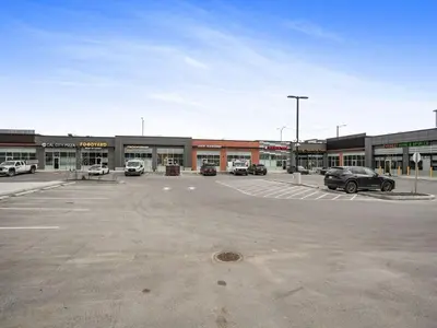 a parking lot with cars parked in front of a building at Deluxe 2-Bedroom Getaway Near Calgary Airport Sleeps Up to 6 in Calgary