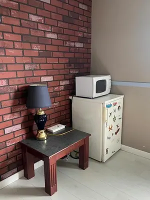 a small table with a microwave on top of a refrigerator at Valemount Hotel in Valemount