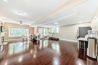 an empty living room with a hard wood floor and a tv at Cozy bedroom in quiet community in Calgary