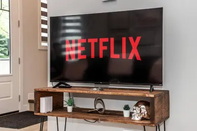 a television on a tv stand with a netflix sign on it at ExoticLUSHquietRetreatKingBed|WIFI|Parking|WEM in Edmonton