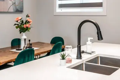 a kitchen with a sink and a table with chairs at ExoticLUSHquietRetreatKingBed|WIFI|Parking|WEM in Edmonton
