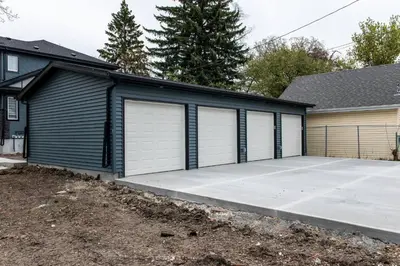 a house with four garage doors and a driveway at ExoticLUSHquietRetreatKingBed|WIFI|Parking|WEM in Edmonton