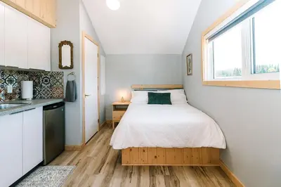a small bedroom with a bed and a window at Bikepack Basecamp in Nordegg