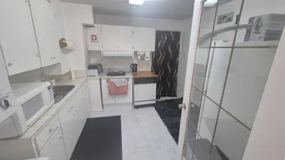 a small kitchen with white cabinets and a sink at The Peaceful Pines in Terrace