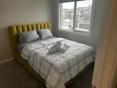 a bed with a stuffed animal on top of it at Bedroom in Keswick C in Edmonton