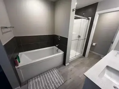 a bathroom with a tub and a shower and a sink at Bedroom in Keswick C in Edmonton