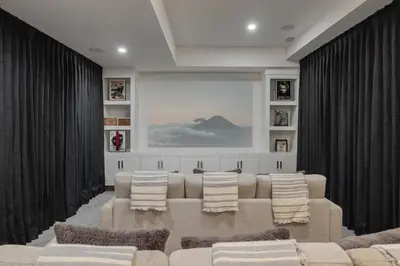 a living room with a couch and a table at Home Theater with AC, Dual Master Suites, BBQ in Calgary