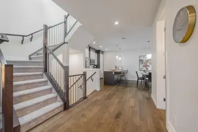 an open hallway with stairs and a dining room at Home Theater with AC, Dual Master Suites, BBQ in Calgary