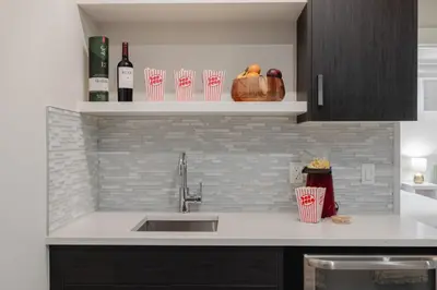 a kitchen counter with a sink and bottles of wine at Home Theater with AC, Dual Master Suites, BBQ in Calgary