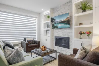 a living room with a couch and a fireplace at Home Theater with AC, Dual Master Suites, BBQ in Calgary