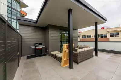 a house with a patio with furniture and a stove at Gyrobeachescape in Kelowna