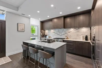 a kitchen with a large island with bar stools at Gyrobeachescape in Kelowna