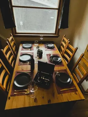 a wooden table with chairs and plates on it at Merlot House in Calgary
