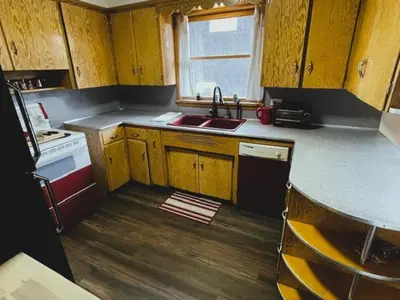 a small kitchen with wooden cabinets and a sink at Merlot House in Calgary