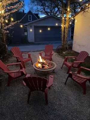 a group of chairs around a fire pit at night at Merlot House in Calgary