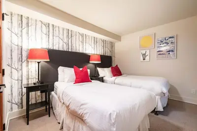 two beds in a hotel room with red pillows at Arrowhead Point 2 by Outpost Whistler in Whistler