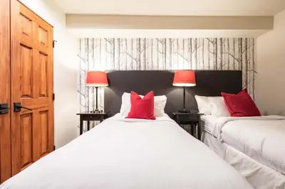 two beds in a room with two red lamps at Arrowhead Point 2 by Outpost Whistler in Whistler