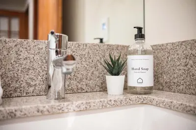 a bottle of alcohol sitting on a counter next to a sink at Arrowhead Point 2 by Outpost Whistler in Whistler