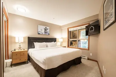 a bedroom with a large bed and a window at Aspens Lodge 220 by Outpost Whistler in Whistler