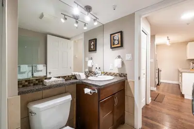 a bathroom with a toilet and a sink and a mirror at Aspens Lodge 220 by Outpost Whistler in Whistler
