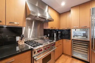 a kitchen with stainless steel appliances and wooden cabinets at Fitzsimmons Walk 10 by Outpost Whistler in Whistler
