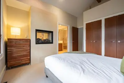 a bedroom with a white bed and wooden cabinets at Fitzsimmons Walk 10 by Outpost Whistler in Whistler
