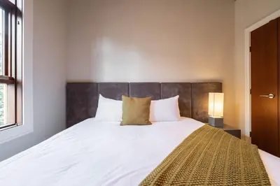 a bedroom with a large bed with white sheets and pillows at Fitzsimmons Walk 10 by Outpost Whistler in Whistler