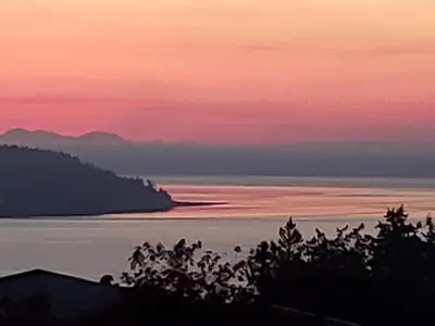 a view of the ocean at sunset at Above Tide Motel in Campbell River