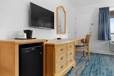 a room with a desk and a television on a wall at Kootenay Lakeview Resort BW Signature Collection in Balfour