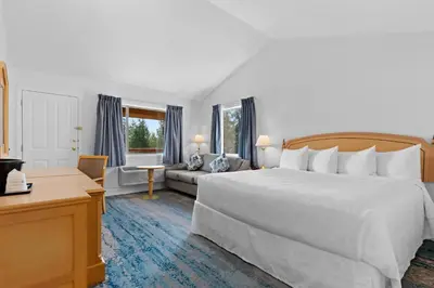 a bedroom with a large white bed and a couch at Kootenay Lakeview Resort BW Signature Collection in Balfour
