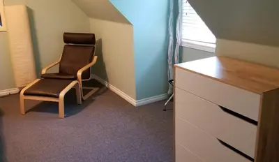 a chair sitting next to a dresser in a room at Silver Star Bed and Breakfast in Vernon