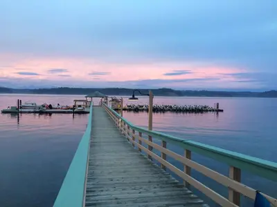 a dock on a lake with a sunset at Painter's Lodge in Campbell River