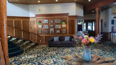 a lobby with a couch and a vase of flowers on a table at Painter's Lodge in Campbell River